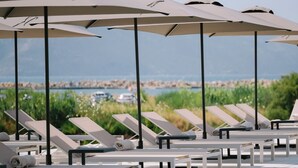 A poolside area with lounge chairs and umbrellas, a clear sky, and a distant view of the sea. - Safin Hotel & SPA (Orikum)