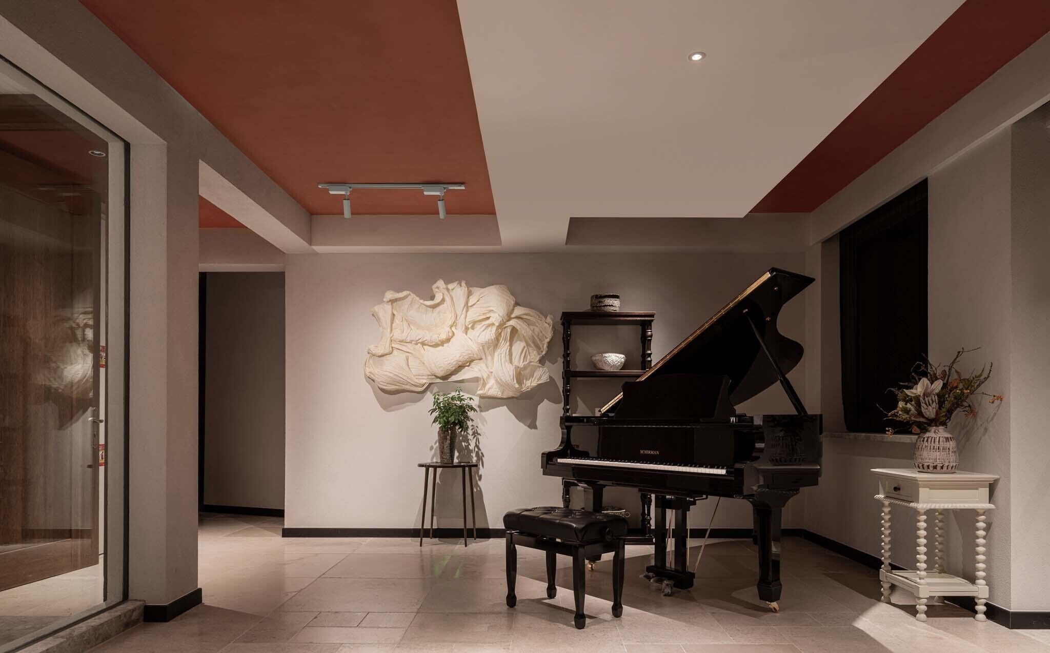 A grand piano in a spacious room with a modern design, a large abstract sculpture, and a small table with a plant.