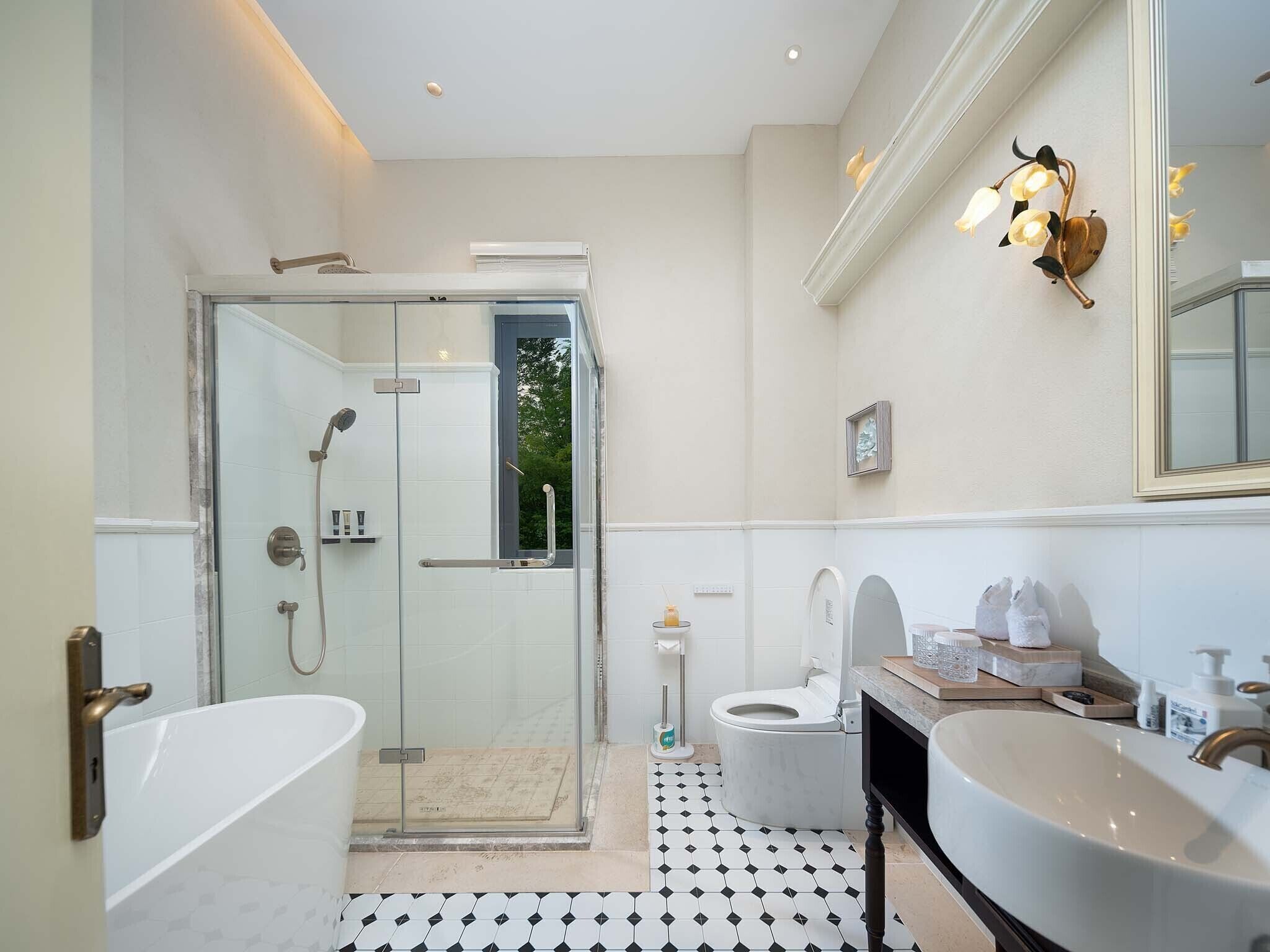 A modern bathroom with a glass-enclosed shower, a freestanding bathtub, a toilet, and a vanity with a sink.