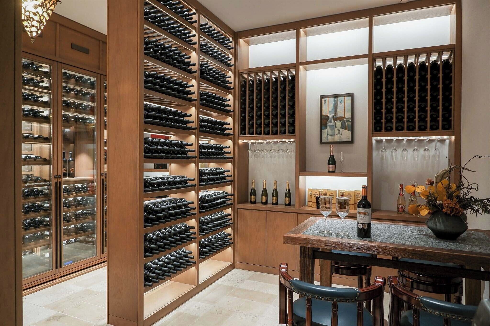 A wine cellar with multiple wine racks and a dining area with a table and chairs.