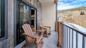 A balcony with two rocking chairs and a view of a snowy landscape. - New Luxury | Keystone Lake | King Bed (Keystone)