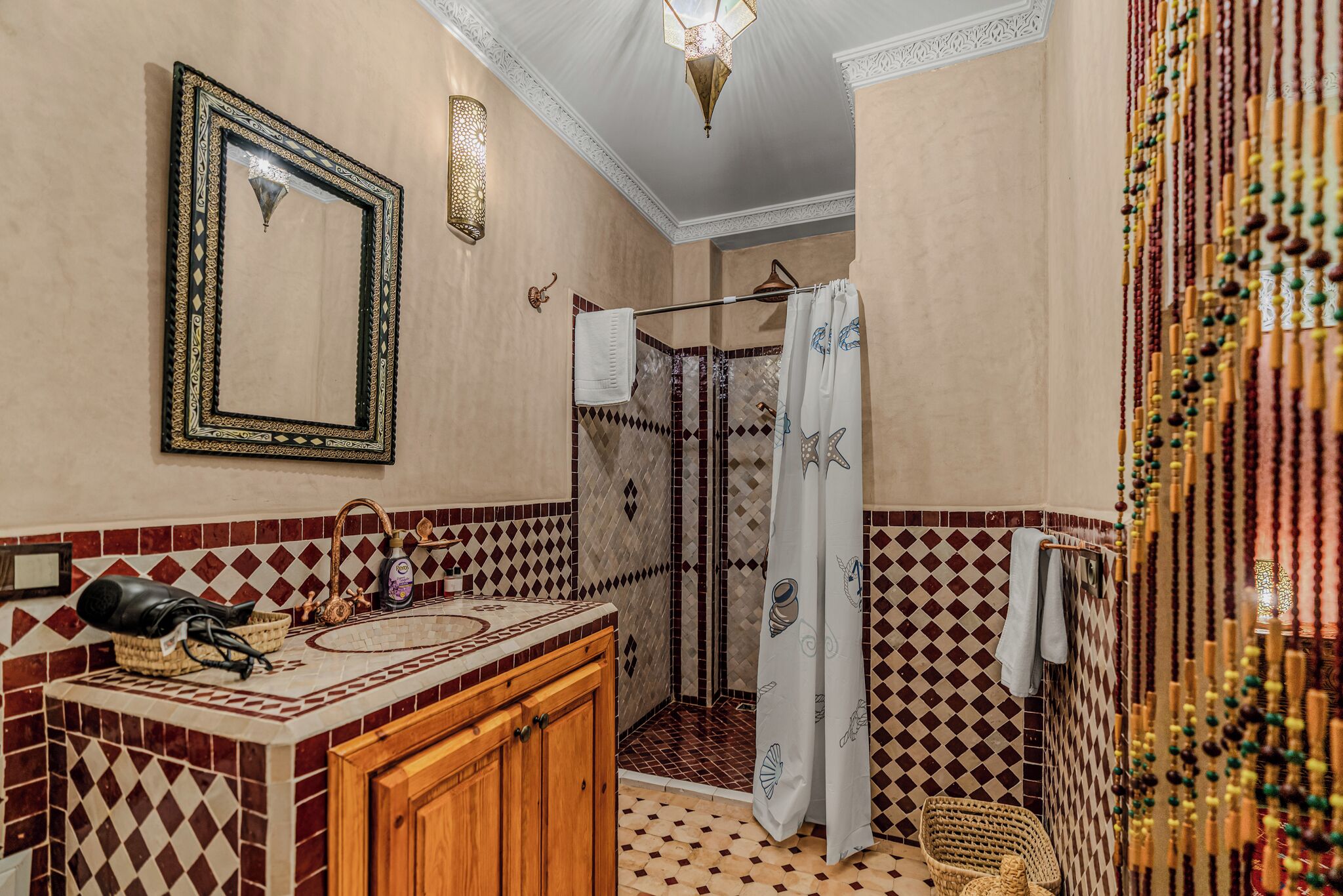 A bathroom with a shower, a sink with a mirror, and a towel rack.