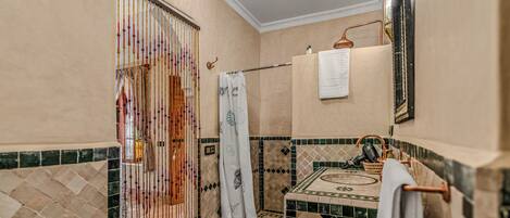 A bathroom with a shower, a towel rack, and a mirror.