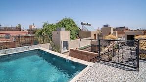 A rooftop swimming pool with a clear view of the cityscape in the background. - Riad Maison D'HÔTE ABDEL & JAMILA (Marrakech)