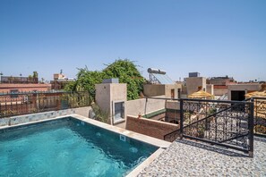 A rooftop swimming pool with a clear view of the cityscape in the background. - Riad Maison D'HÔTE ABDEL & JAMILA (Marrakech)