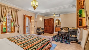 A traditional room with a bed, a wooden wardrobe, a small table, and a decorative lamp. - Riad Maison D'HÔTE ABDEL & JAMILA (Marrakech)