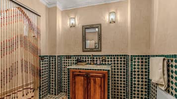 Un baño con un mueble de madera, un lavabo y un espejo.