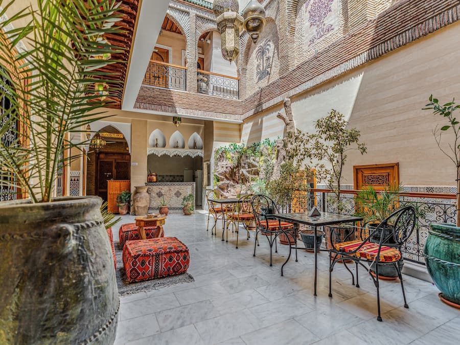 A spacious indoor courtyard with a seating area, potted plants, and a decorative wall.