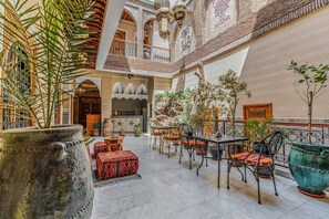 A spacious indoor courtyard with a seating area, potted plants, and a decorative wall. - Riad Maison D'HÔTE ABDEL & JAMILA (Marrakech)