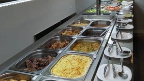 A buffet line with various food options including meats, salads, and rice dishes. - Pera Imperial hotel (Iringa)