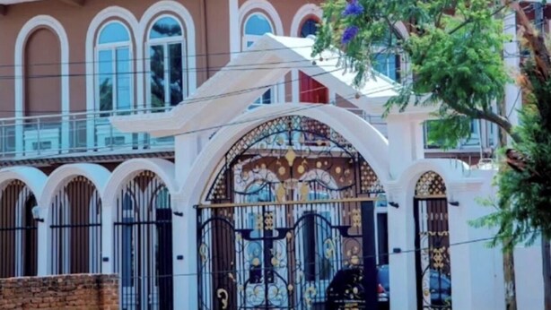A building with a sign reading "PERAIMPERIAL HOTEL" and a gated entrance with ornate metalwork. - Pera Imperial hotel (Iringa)