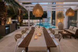 An outdoor pool area with a wooden table, wicker chairs, and a sofa. - Themis Luxury Villa Rhodes, Villa (Ialisos)