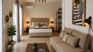 Una sala de estar moderna con un sofá, una mesa de centro y una cama con cabecera. Hay plantas en macetas, un cuadro y una lámpara.