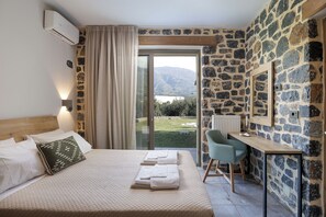 A bedroom with a bed, a desk, a chair, and a view of the outdoors. - Kozilis Estate Zita Villa, Villa (Plakias)