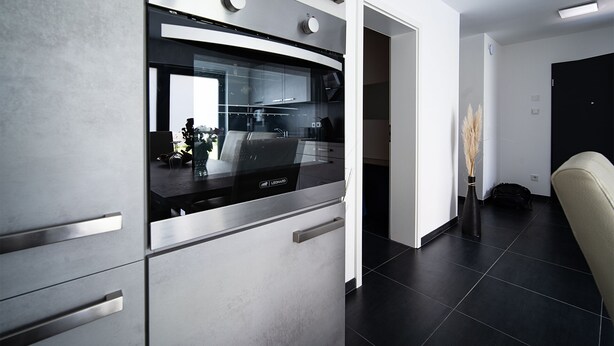 A modern kitchen with stainless steel appliances, a glass backsplash, and a minimalist design. - Blauer Stein - Echo bl7a-haus (Pulheim)