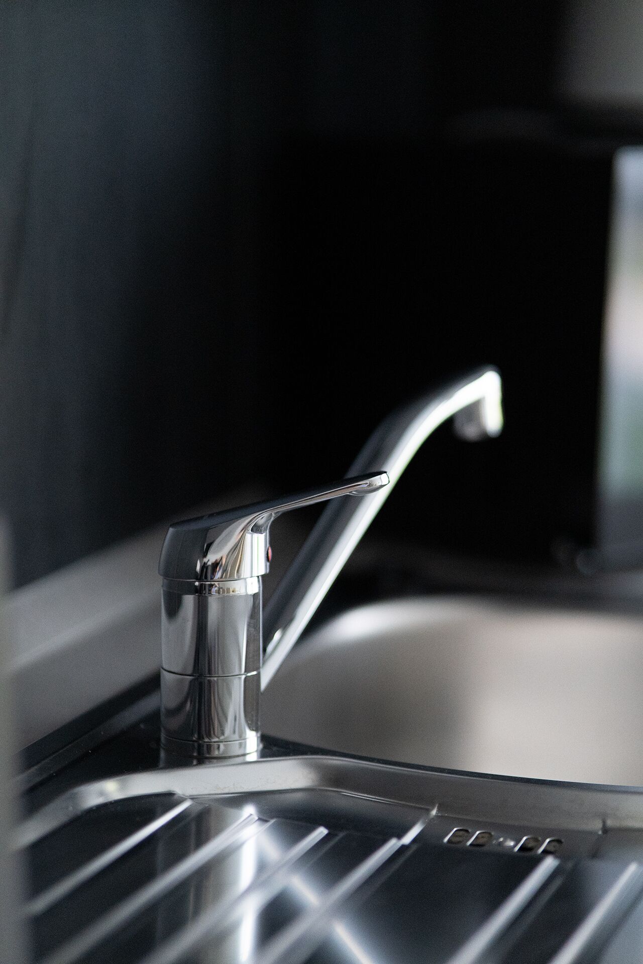 A modern kitchen sink with a sleek faucet and a stainless steel basin.
