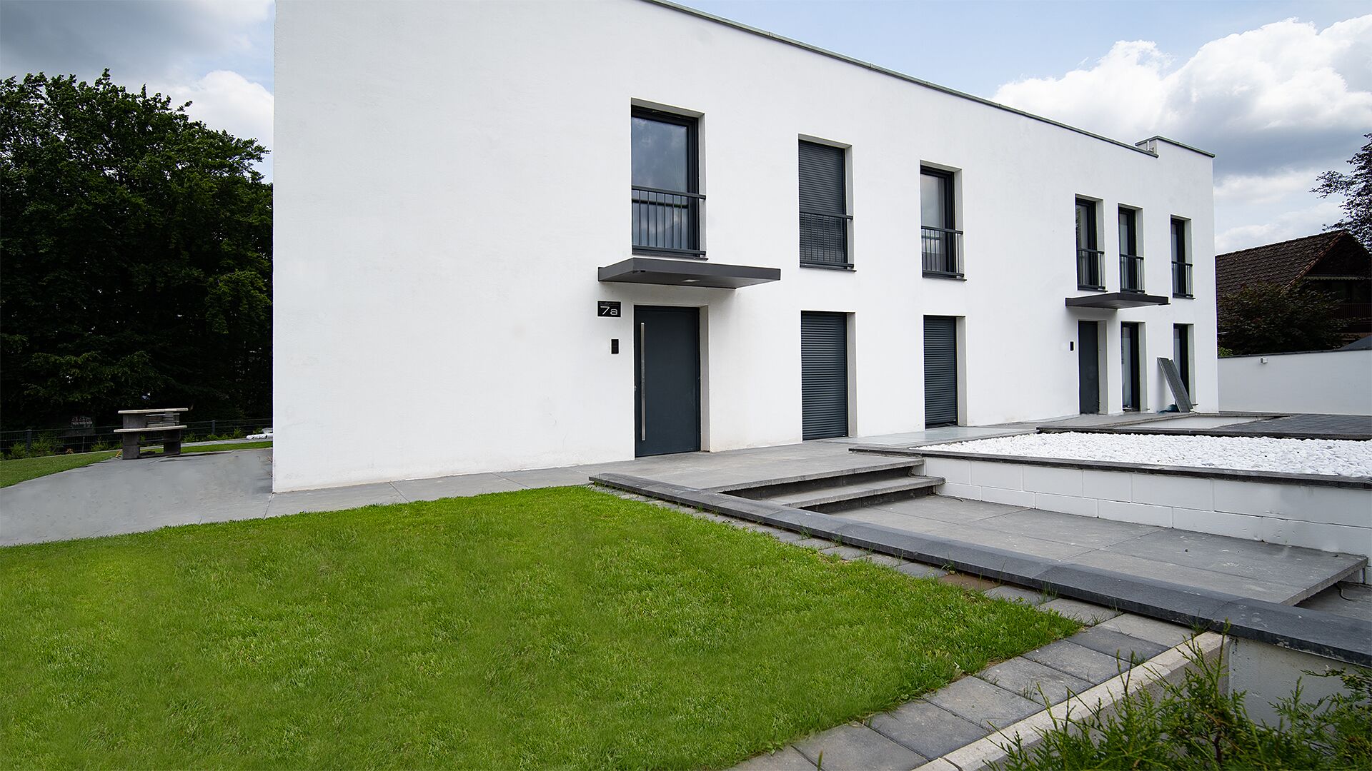 Un bâtiment moderne à deux étages, doté d’un toit plat, de grandes fenêtres et d’une pelouse bien entretenue.