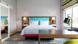 Una habitación de hotel con cama, mesitas de noche, escritorio y una silla.