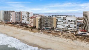 Un hotel a la costa amb diversos edificis alts, platja i zona de piscina.