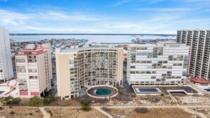 Un edifici alt amb nombroses balconades i una zona de piscina circular.