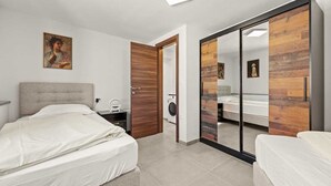 A modern bedroom with a large bed, a wardrobe with a mirror, and a painting on the wall. - Holiday Apartment Toronda (Vrvari-Poreč)