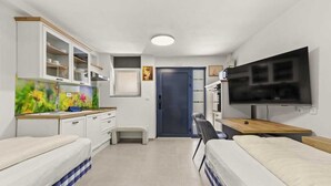 A compact hotel room with a kitchenette, a bed, a desk, and a TV. - Holiday Apartment Vanga (Vrvari-Poreč)