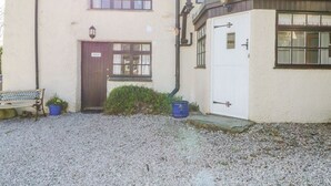 A building with a gravel driveway, a wooden bench, and a door labeled "ANNEXE". - Farmhouse Cottage (Keswick)