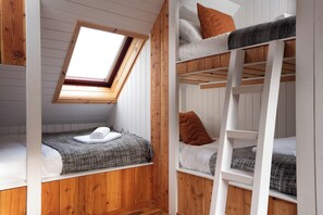 Un dormitorio con literas, un tragaluz y paredes de madera.