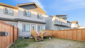 A residential area with multiple houses, a wooden deck, and a grassy yard. - Modern 3BR Home Edmonton Near by Airport (Edmonton)