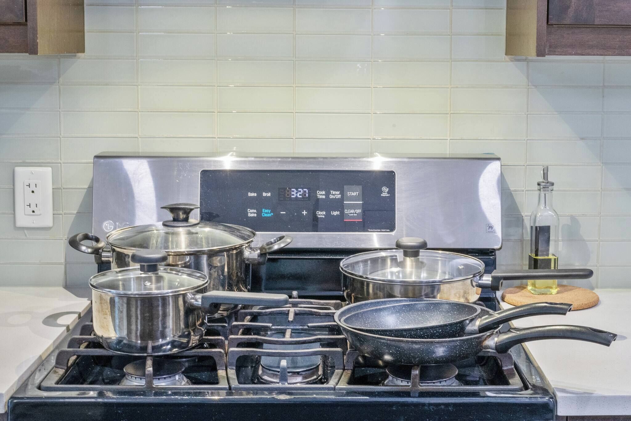 A kitchen with a stainless steel stove, pots, and pans.