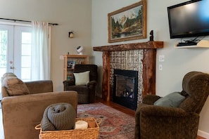 A living room with a fireplace, a television, and a bookshelf.