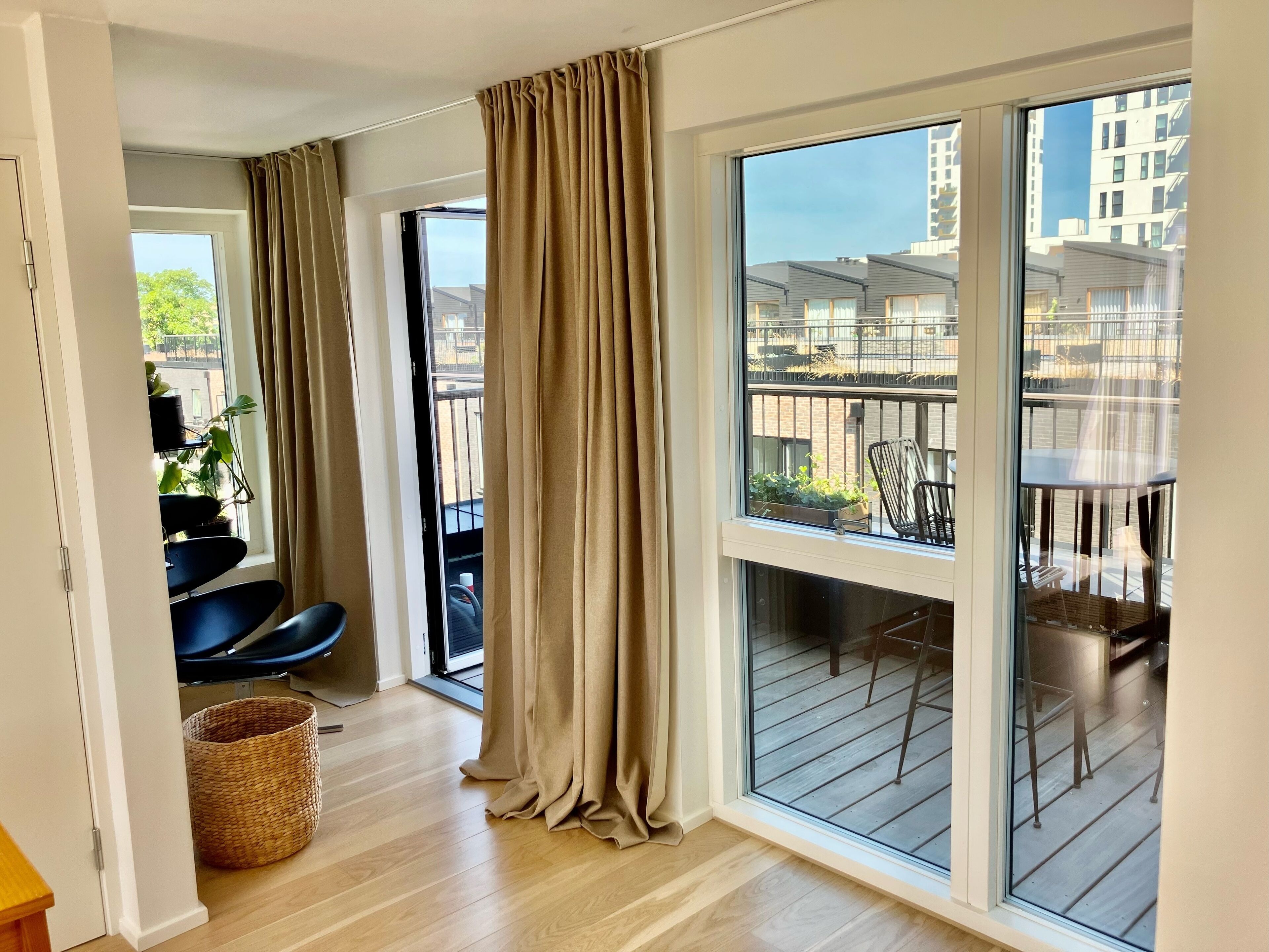 Een balkon met uitzicht op de stad, een stoel en een mand.