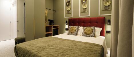 A bedroom with a large bed, a red headboard, and decorative wall art.