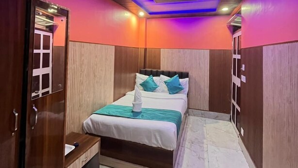 Una camera da letto con un letto, un comodino, un armadio e un soffitto illuminato di blu.