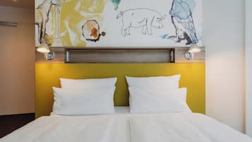 Habitación de hotel con cama, dos lámparas de noche y una pared decorada con arte abstracto.