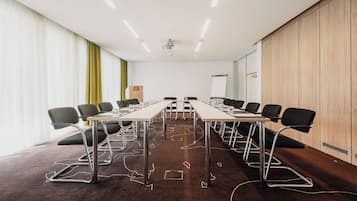 A conference room with a long table, chairs, a projector, and a whiteboard.