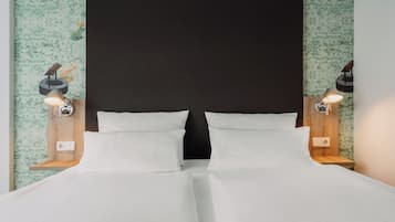 A double bed with a dark headboard and two bedside lamps.