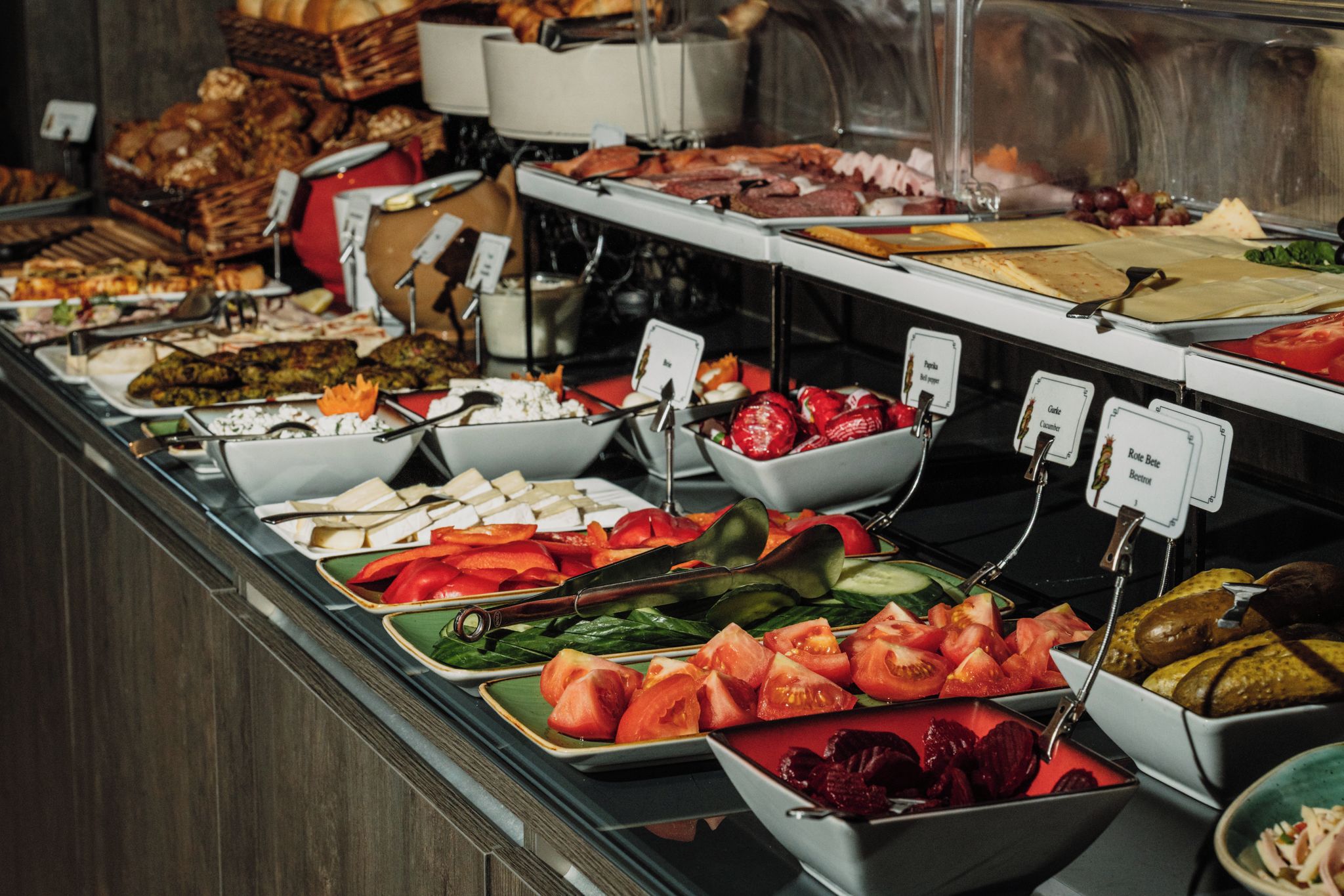 A buffet with various food items including fruits, vegetables, and meats.