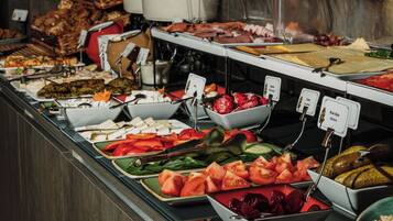 A buffet with various food items including fruits, vegetables, and meats.