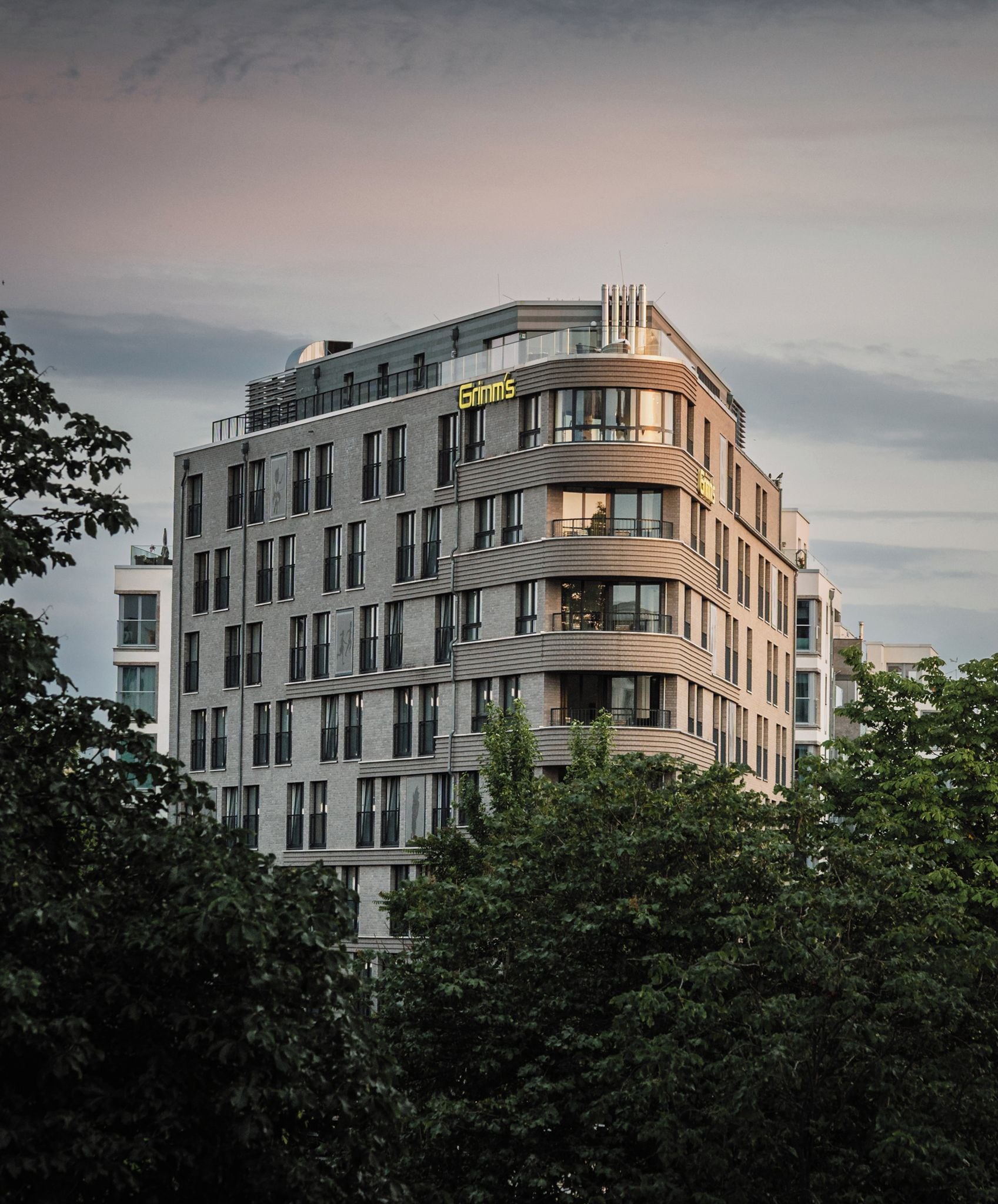 A multi-story hotel with a modern design, featuring balconies and large windows.