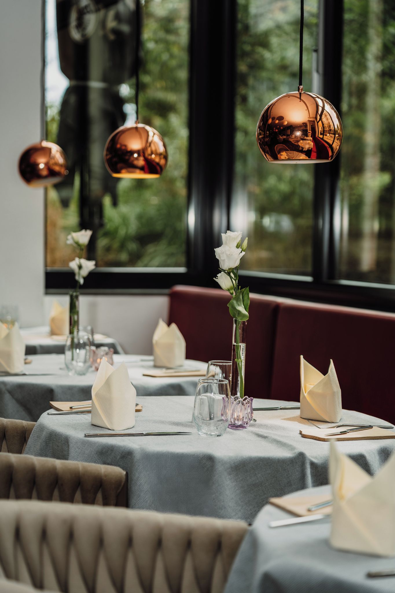 Een restaurantscène met gedekte tafels en een uitzicht door het raam.