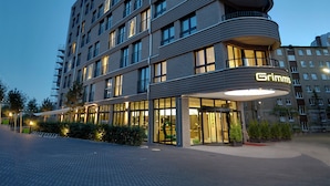 Ein mehrstöckiges Hotel mit modernem architektonischen Design, das auf jeder Etage Balkone und eine gut sichtbare Beschilderung bietet.