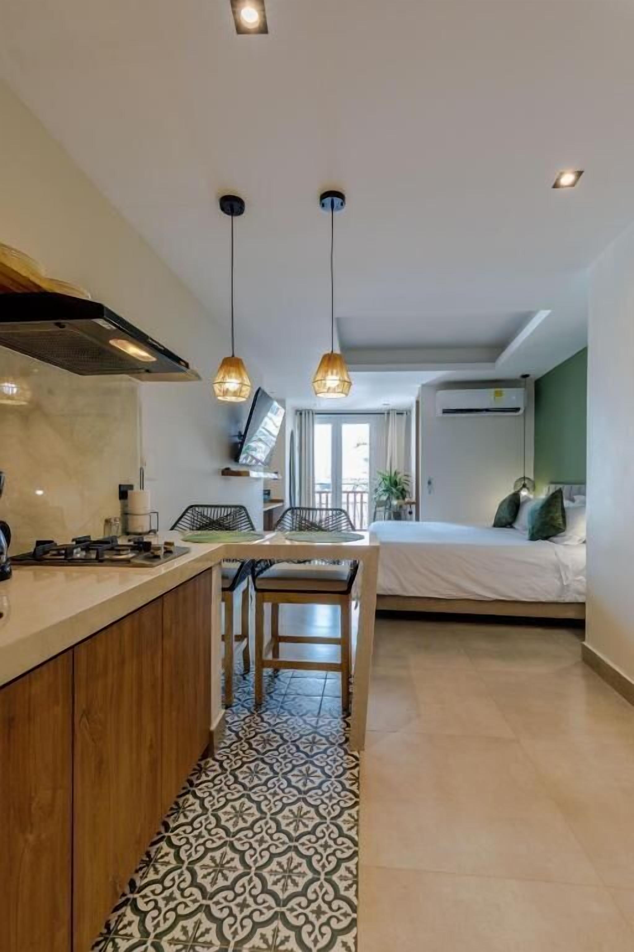 Een moderne keuken met een centraal eiland, hanglampen en een vloer met een patroon.