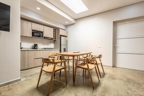 A modern kitchen with wooden cabinets, a microwave, and a coffee maker. - De la Cruz Studio apartments (Cartagena)