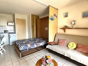 A compact room with a bed, a small kitchenette, a dining area, and a bathroom. - Cozy studio, sea view - 2 guests (Banyuls-sur-Mer)