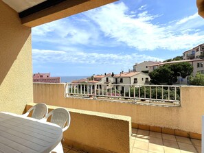 A balcony with a view of the sea and neighboring buildings. - Cozy studio, sea view - 2 guests (Banyuls-sur-Mer)