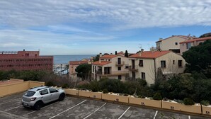 Zona residencial con edificios, un estacionamiento y vista al mar.