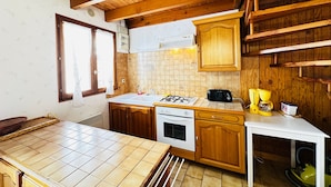 Una cucina con mobili in legno, un piano di lavoro bianco, un fornello e un lavandino.