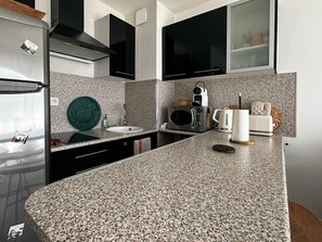 Eine moderne Küche mit Granit-Arbeitsplatten, einer integrierten Mikrowelle, einer Kaffeemaschine und einem Toaster.