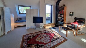 Ein Zimmer mit einem Bett, einem Schreibtisch, einem Stuhl, einem Fernseher und einem Bücherregal.